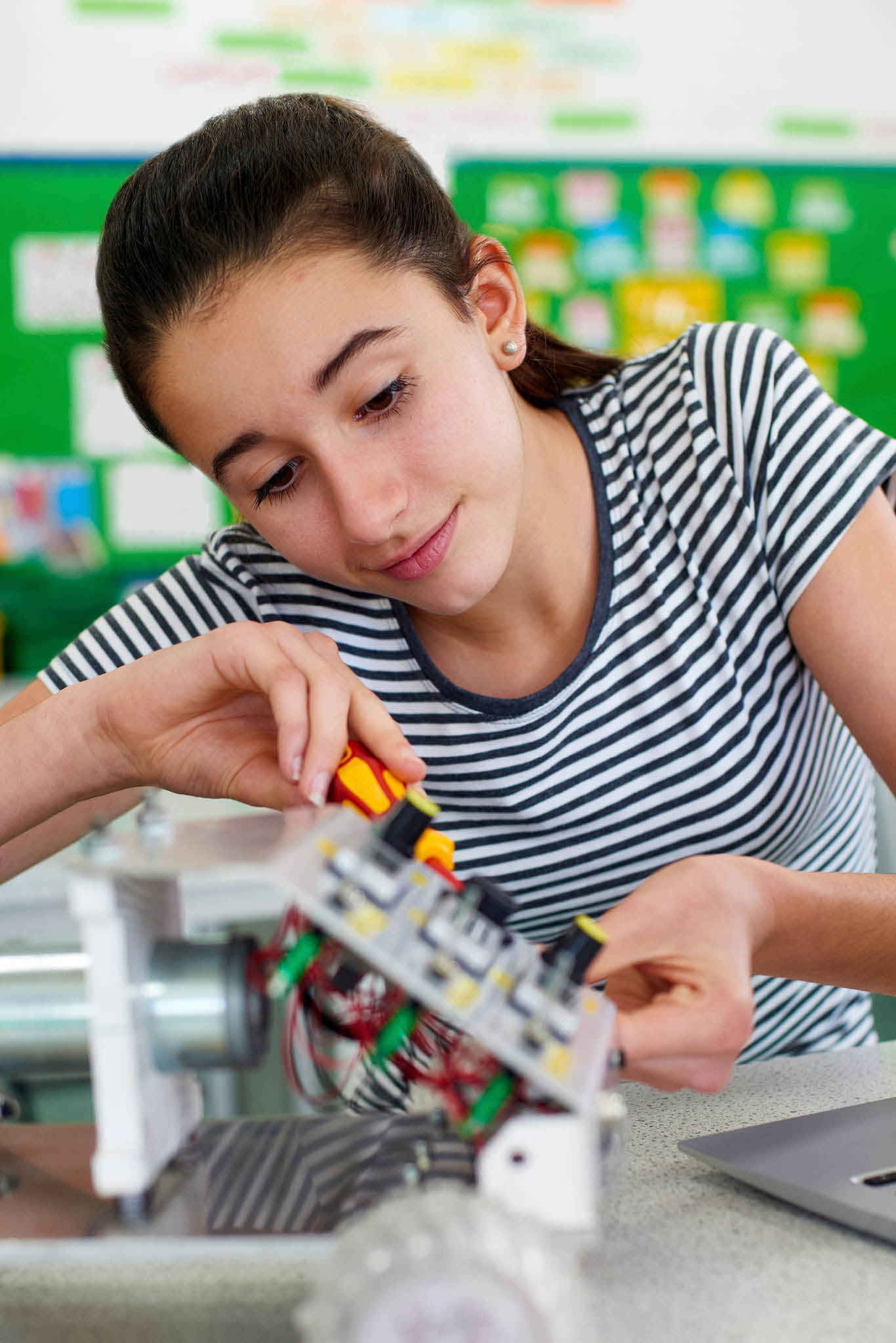 Female Pupil In Science Lesson Studying Robotics
